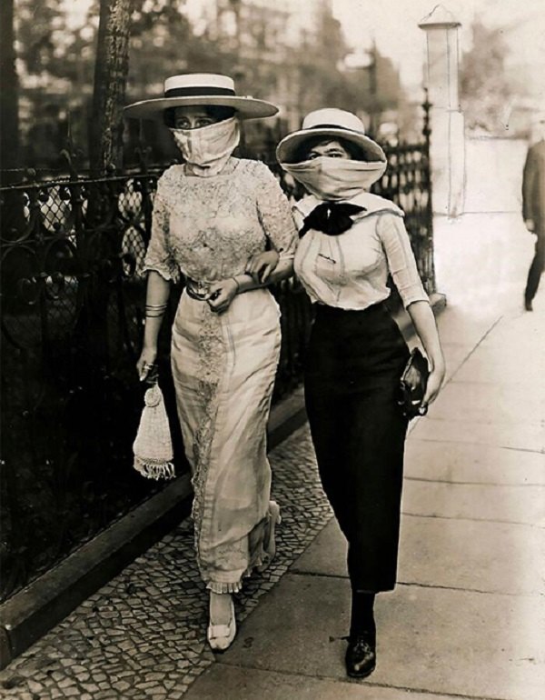 Due donne passeggiano col volto coperto 