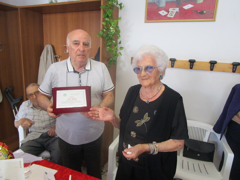 Carlo Fiorani, vicepresidente dell'Associazione Anziani consegna una targa ricordo a Catina 