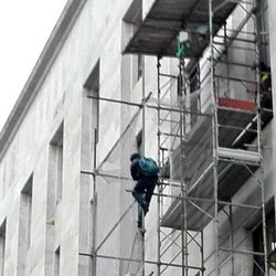 L'uomo arrampicato su un'impalcatura all'esterno del Tribunale di Milano 