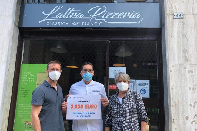 il sindaco Micheli e l'assessore Caretti con uno dei commercianti premiati 