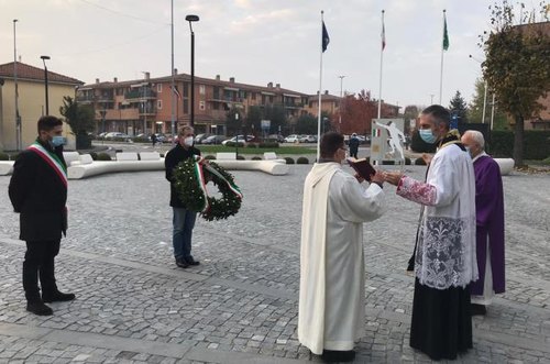 Il parroco, don Flaminio, benedice una delle corone di fiori in omaggio ai Caduti 