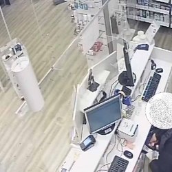 Il rapinatore in azione in una farmacia 