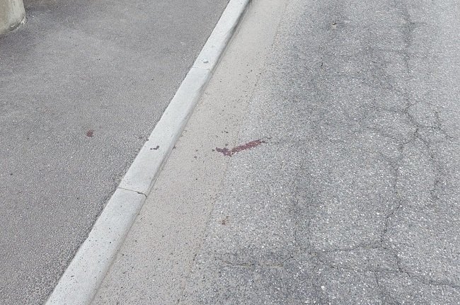 Una macchia di sangue rimasta sull'asfalto sul luogo dell'aggressione 