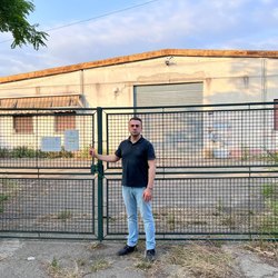 il consigliere Francesco Rocca (FdI) davanti al capannone che la Giunta Sala vuole dare al Leoncavalo 