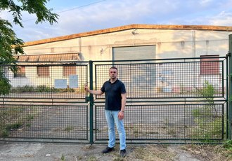 il consigliere Francesco Rocca (FdI) davanti al capannone che la Giunta Sala vuole dare al Leoncavalo 