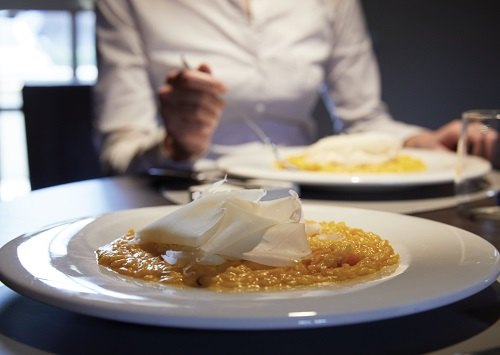 Risotto giallo con raspadura del Lodigiano, delicata sfoglia di formaggio, tipicamente un Grana giovane, ottenuta raschiando la superficie della forma con un coltello speciale 